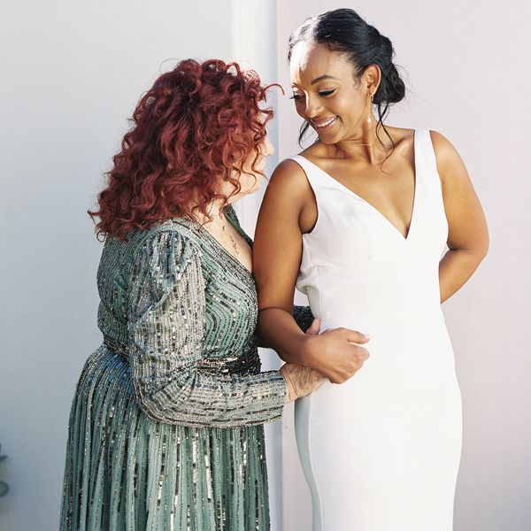 bride and mother of the bride, who's wearing a green sequin dress, holding hands