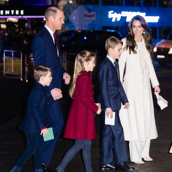 Prince William, Kate Middleton, and their three children walking across the street at night