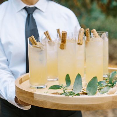 server holding a wooden tray of cocktails