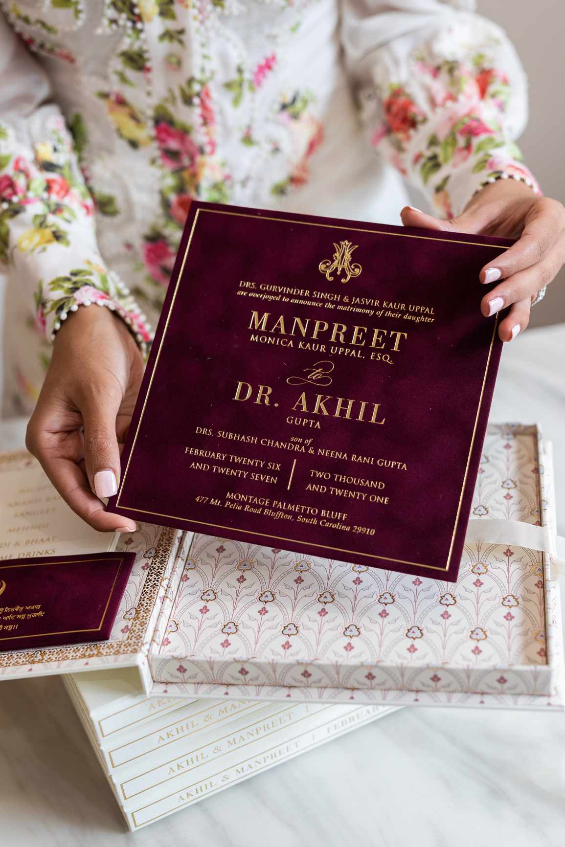 A burgundy and gold boxed wedding invitation.