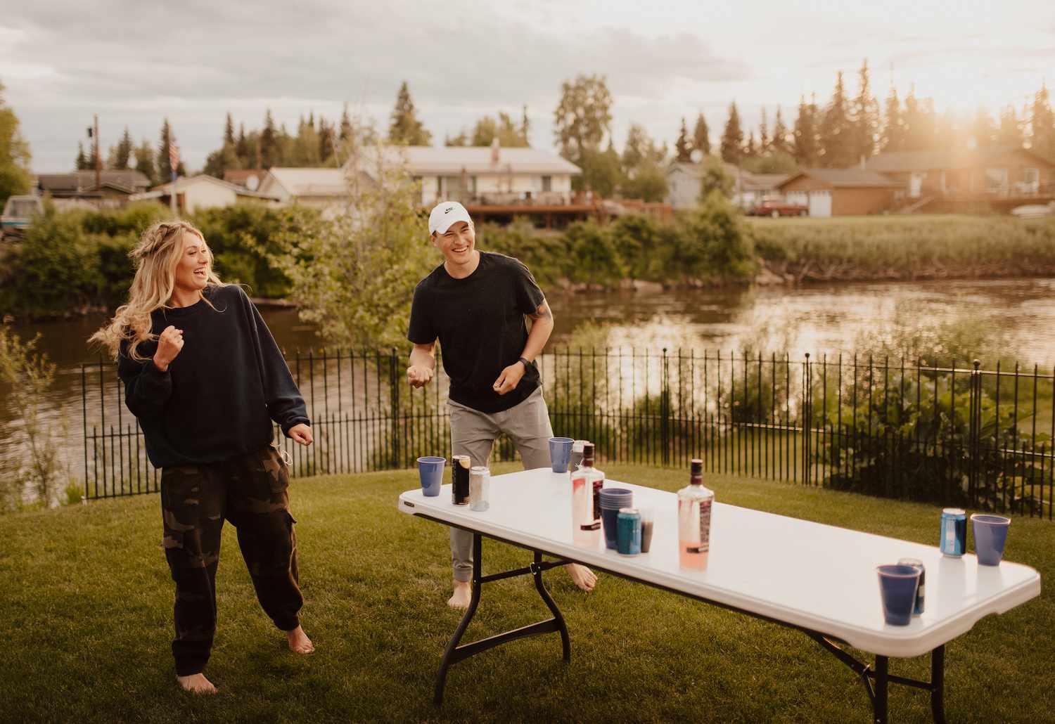 Friends playing drinking games outside in front of a river