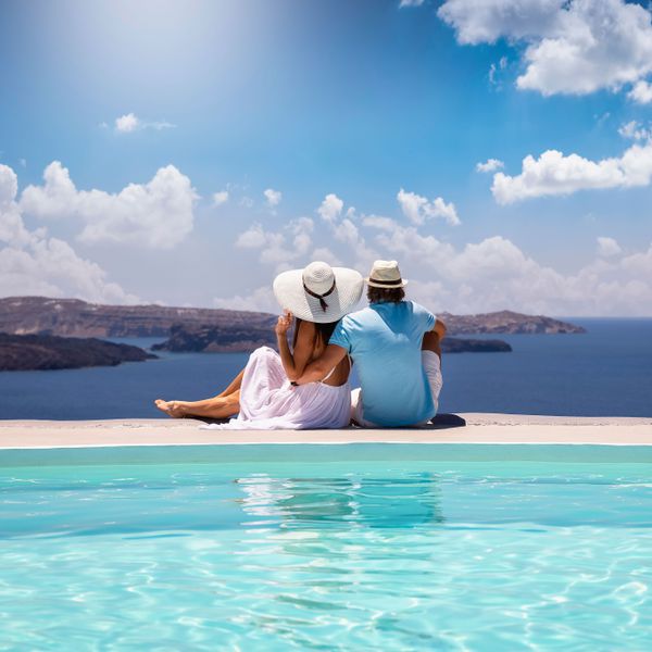 Couple sitting next to infinity pool overlooking the ocean