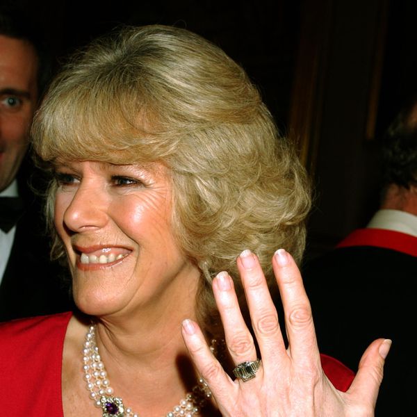 Queen Camilla Holding Up Her Left Hand With Her Emerald-Cut Diamond Engagement Ring on Her Ring Finger