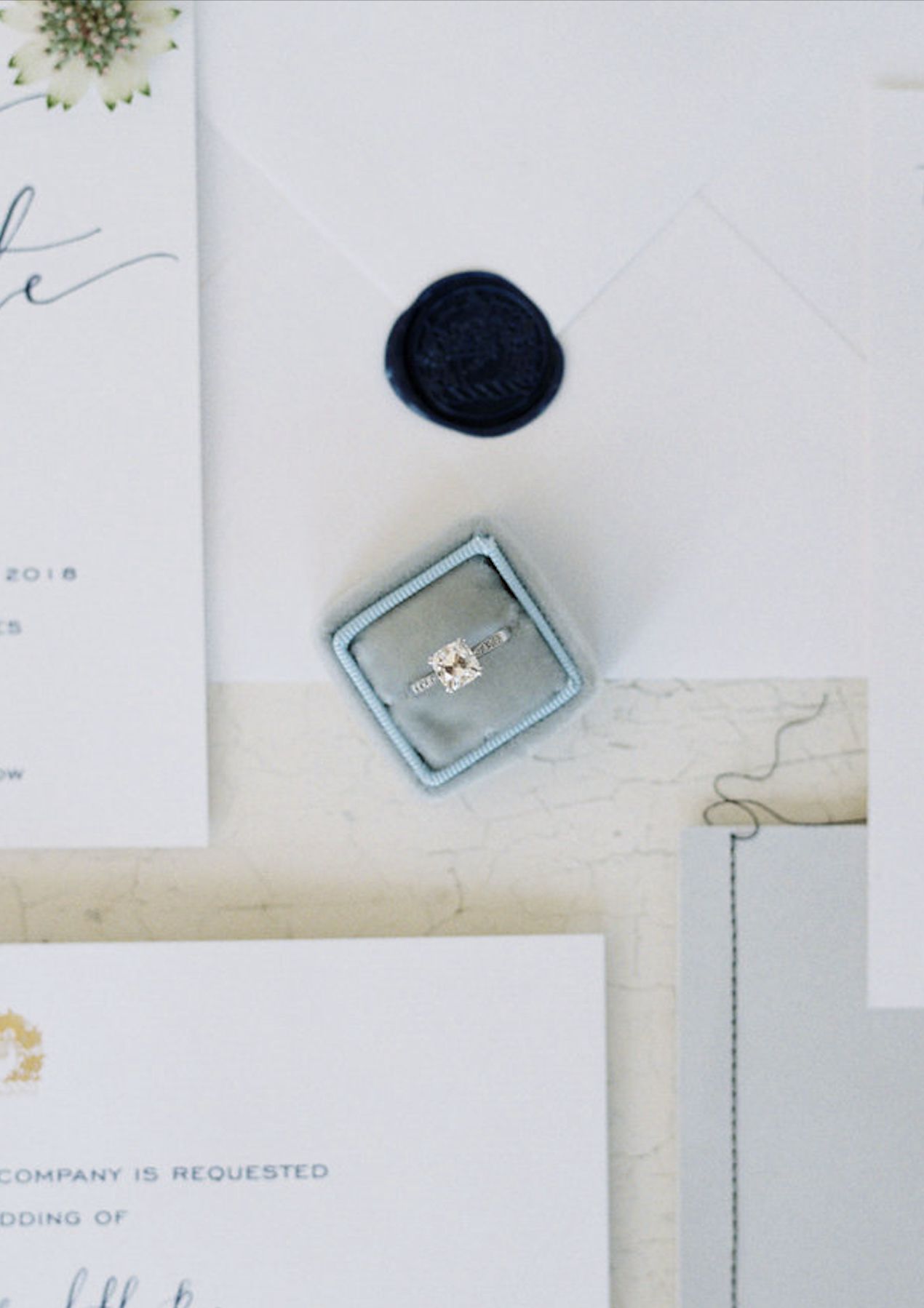 cushion-cut engagement ring sitting in a light blue ring box