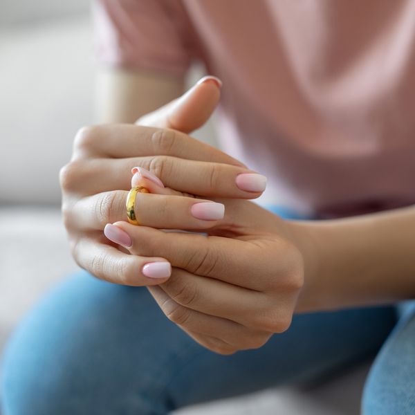 Woman Removing Gold Band from Ring Finger