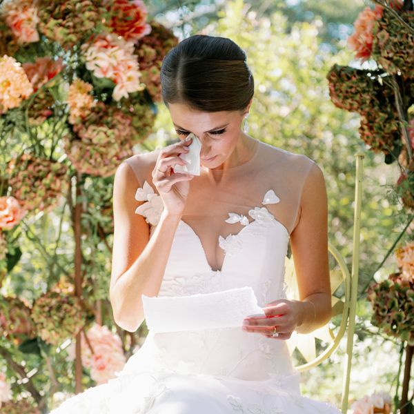 Bride Wiping Her Tears With a Tissue as She Reads a Letter