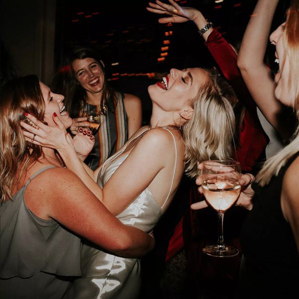 Women drinking and dancing at wedding after-party