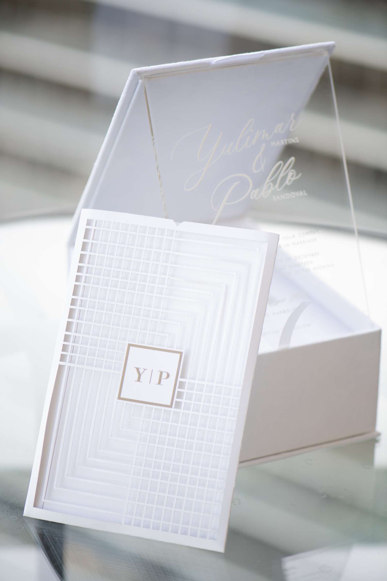 A white and acrylic boxed wedding invitation featuring mixed materials.