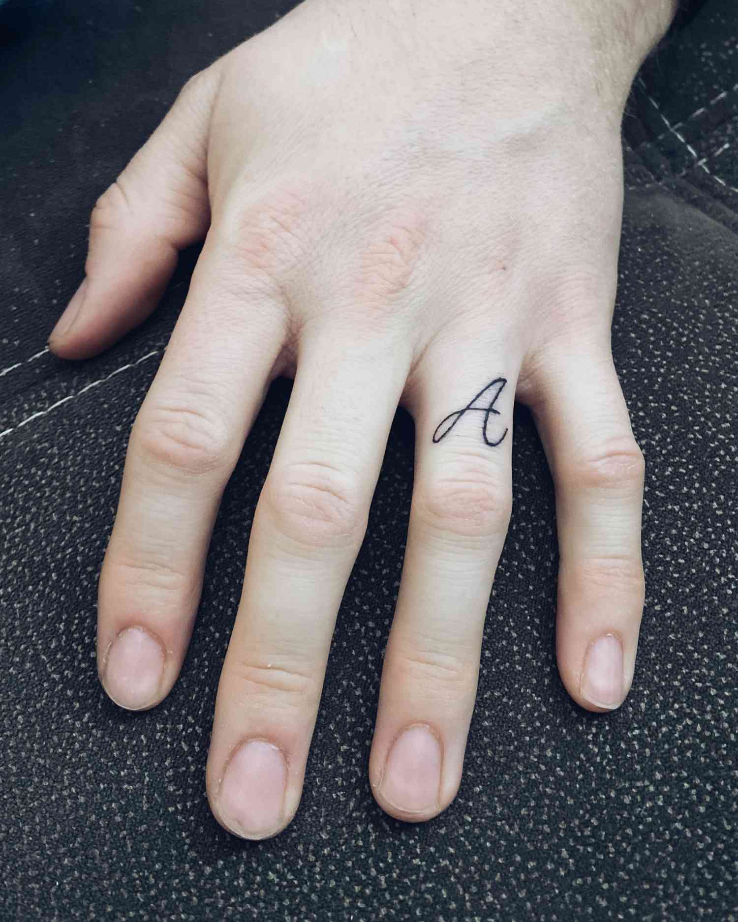 Hand with wedding ring finger tattoo