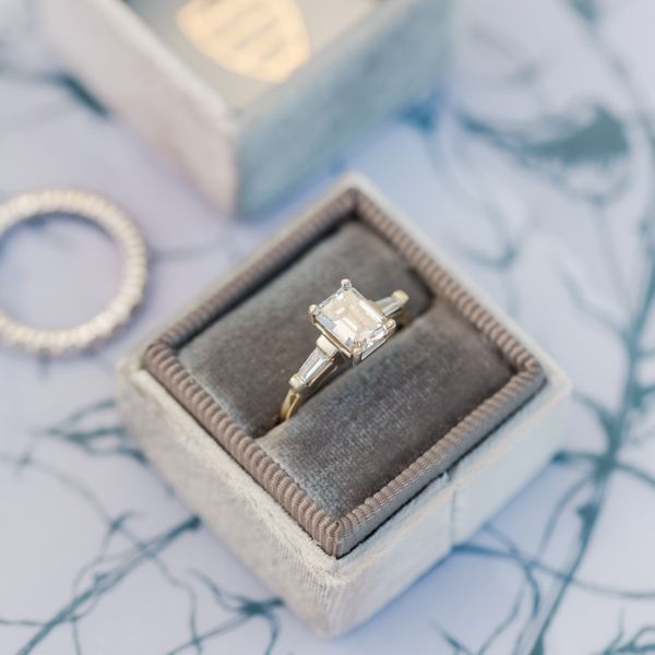 silver emerald cut diamond ring in a grey ring box