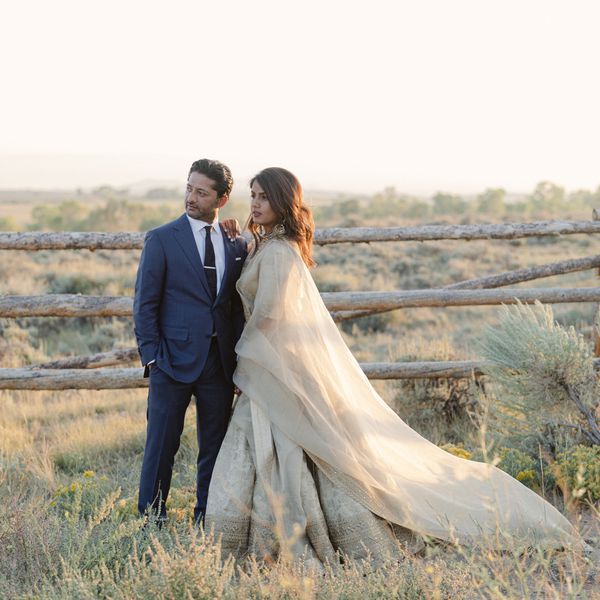 Groom in Blue Suit and Bride in Gold Gown Posing for Wedding Portrait at Sunset