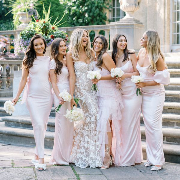 Bridesmaids in Baby Pink Satin Dresses Smiling With the Bride