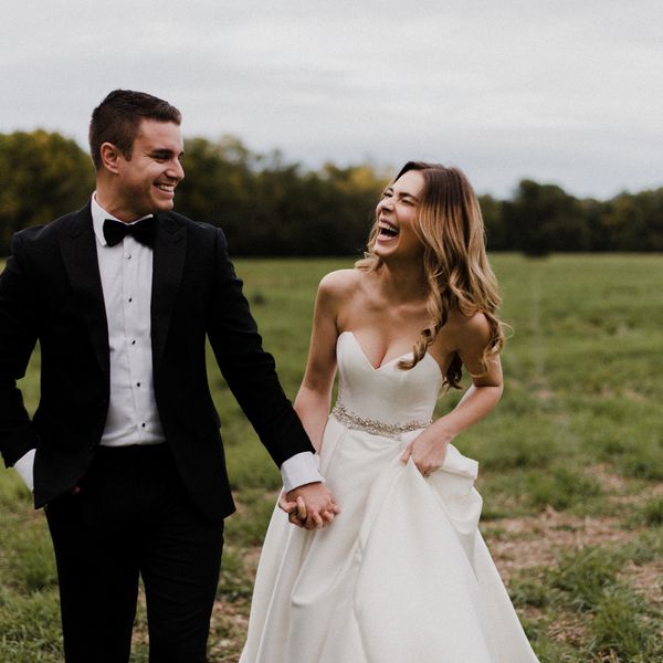 Happy bride and groom holding hands in a field