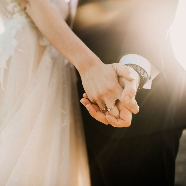 Close-Up Shot of Bride and Groom's Hands Clasped Together