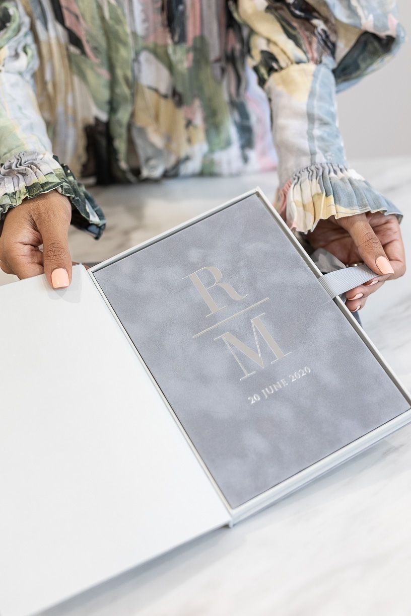 A monogrammed gray boxed wedding invitation.