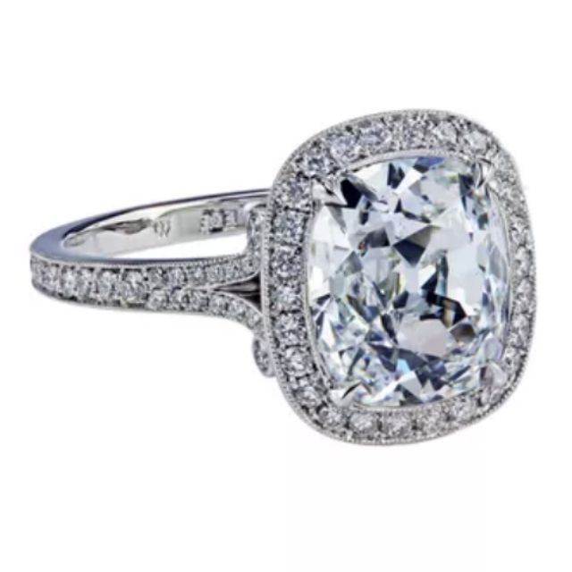 halo engagement ring featuring True Antiqueâ¢ cushion Blondeâ¢ Moissanite, with a 8Ã6 mm center stone surrounded by bright-cut pave diamonds 