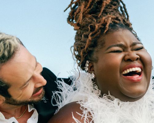 Gabourey Sidibe in White Feather Dress with Hair Up and Brandon Frankel in Black Jacket 