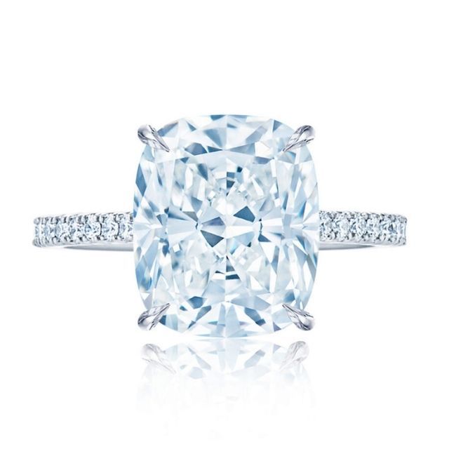 cushion cut solitaire diamond secured tapered prongs and a hidden pavÃ© halo mounted atop a Platinum and pavÃ© band