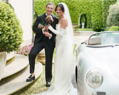 Influencer Christine Le in White Sheath Wedding Dress With Veil and Gloves With Husband and Dog in Front of Porsche