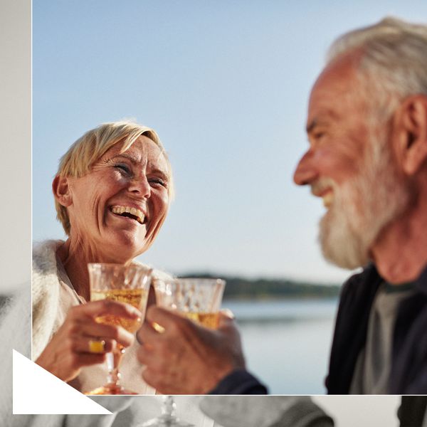 Older Couple Smiling and Having Cocktails in Front of Lake