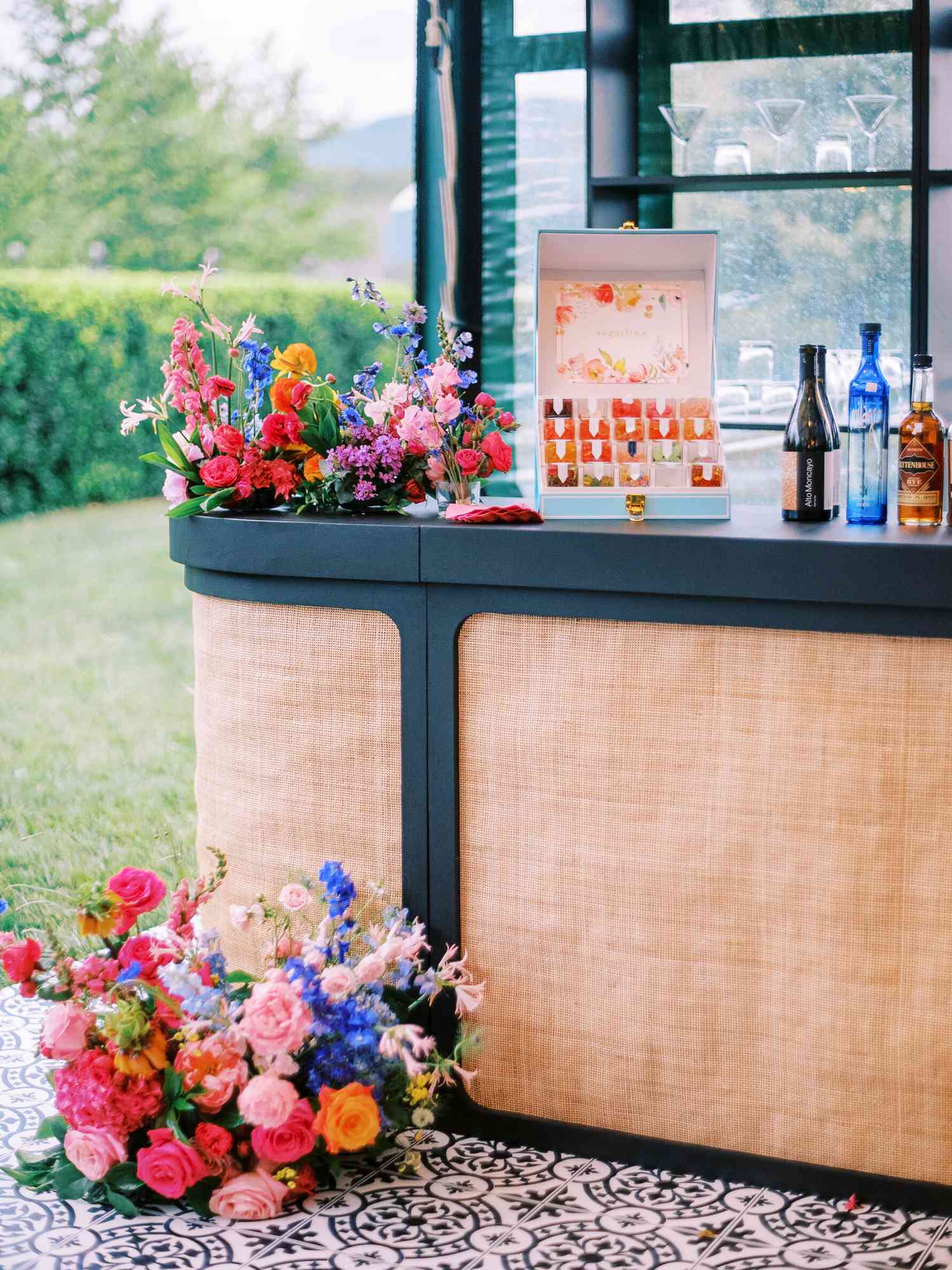 bar with rainbow-hued flowers as decor