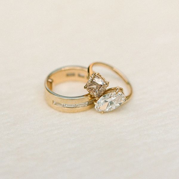 two gold wedding rings: one diamond wedding band and one toi et moi diamond engagement ring