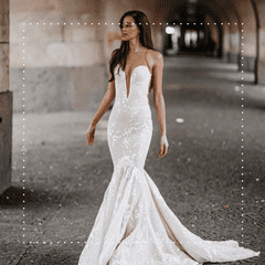 Bride wearing a white sparkly wedding dress while standing near stone outdoor arcade arches