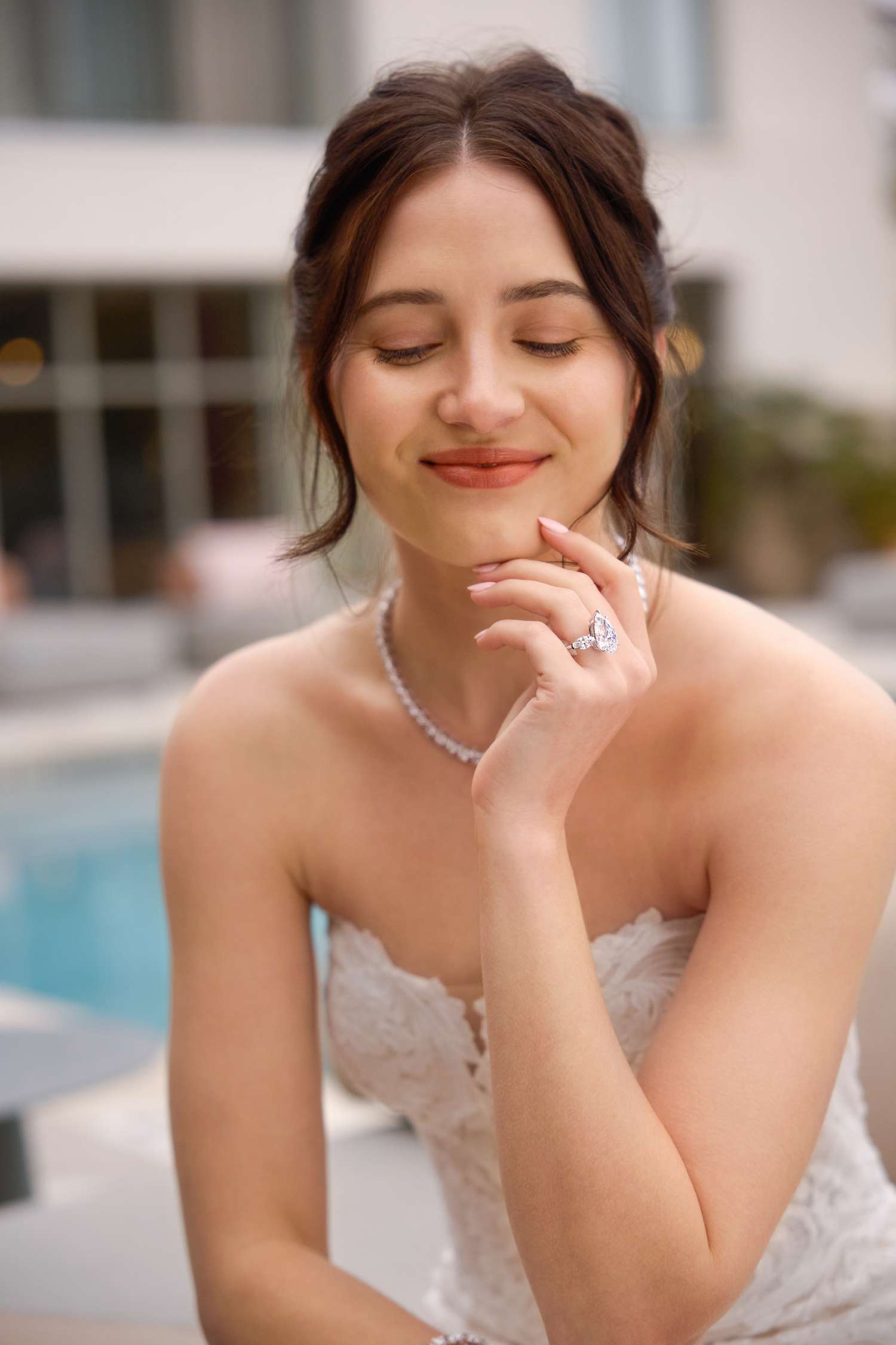 bride wearing a diamond engagement ring, tennis necklace, and tennis bracelet