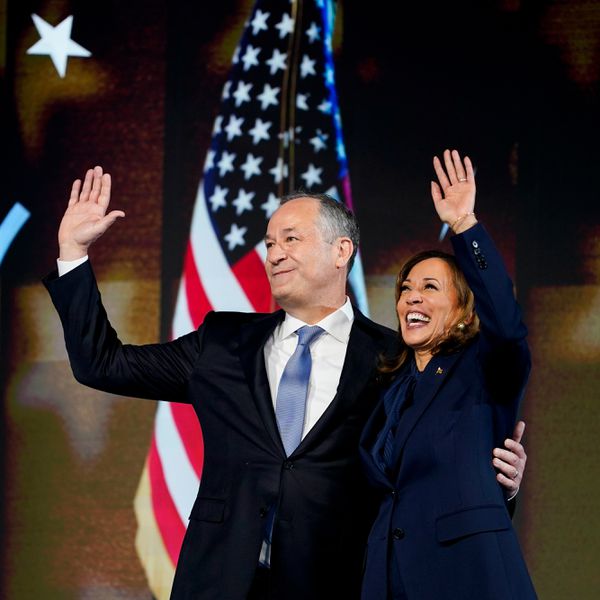 Vice President Kamala Harris and Second Gentleman Doug Emhoff Wave in Front of Flag