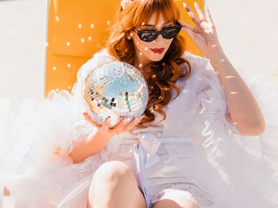 bride wearing a tulle robe holding a disco ball