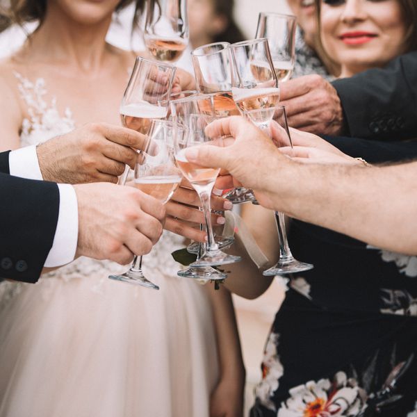 Bride, Groom, and Wedding Guests Toasting With Champagne Flutes