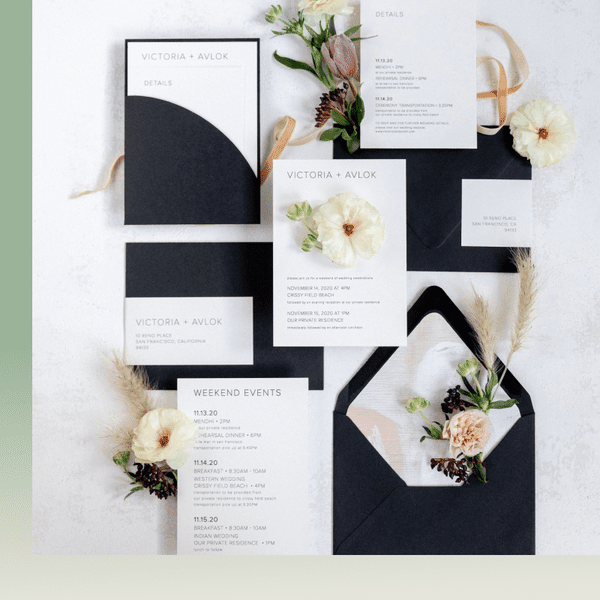 Black and white wedding invitation suite flat lay with pastel blooms