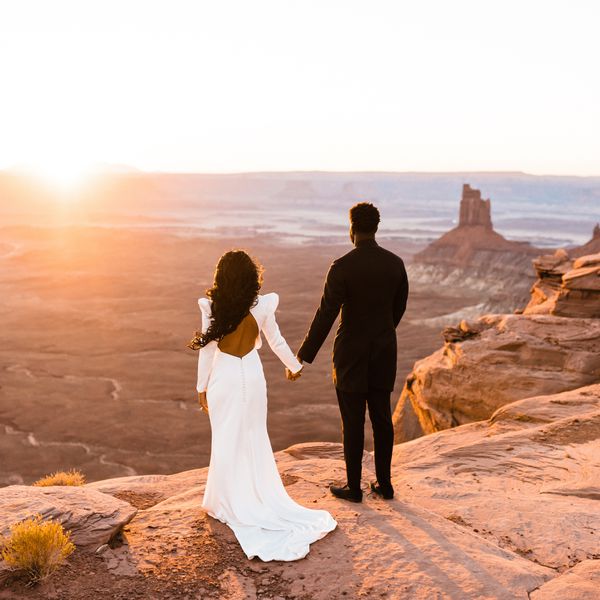 bride and groom holding hands and looking at desert