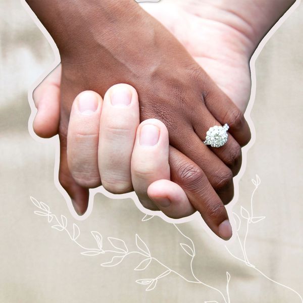 Two hands held together showcasing a round cut engagement ring