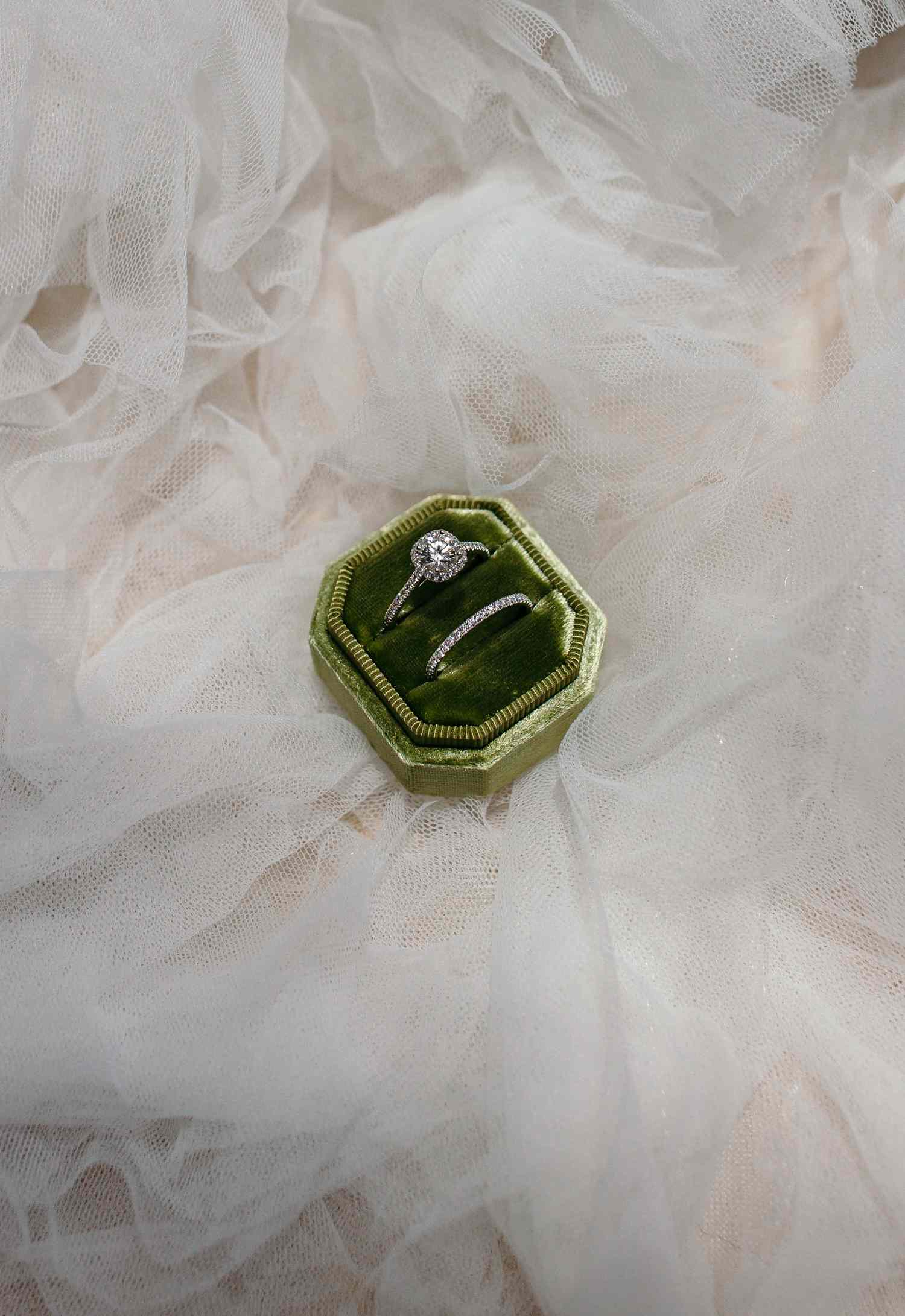 engagement ring and wedding band in a velvet green ring box