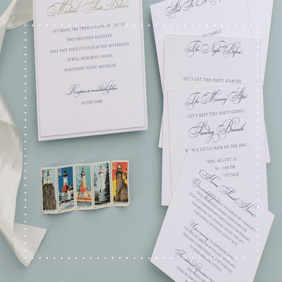 Invitation suite on blue background with lighthouse stamps