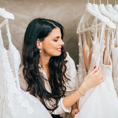 Brunette woman looking at wedding dresses on the rack