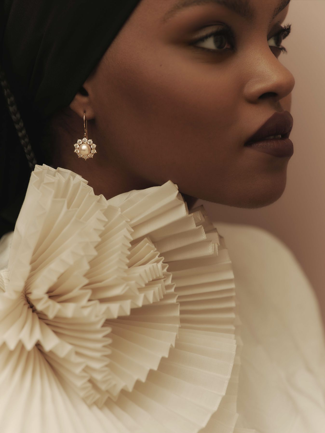 close up of model wearing pearl drop earrings