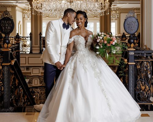 A regencycore wedding in a castle with a hanging chandelier behind the bride and groom