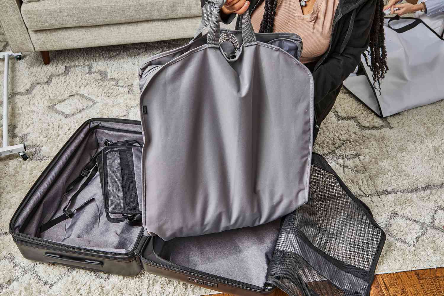 a person picking up the WallyBags Deluxe Garment Bag