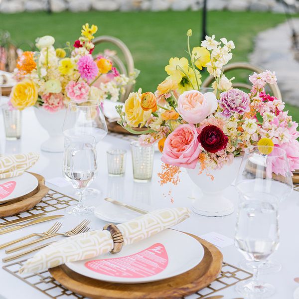 White Vase With Pink, Yellow, Purple, and Red Flowers and Wooden Charger With Patterned Napkin and Pink Menu