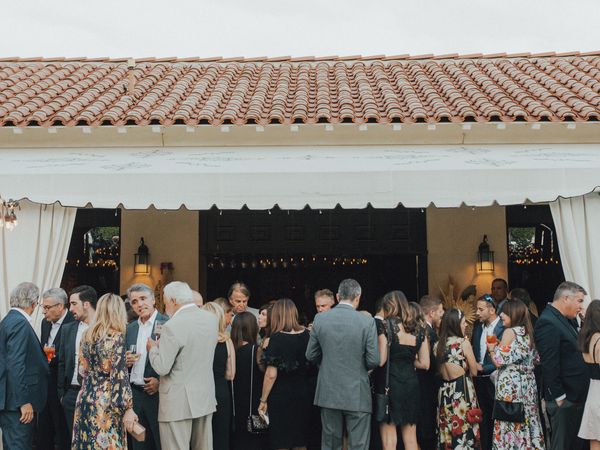 wedding guests under pergola at cocktail hour