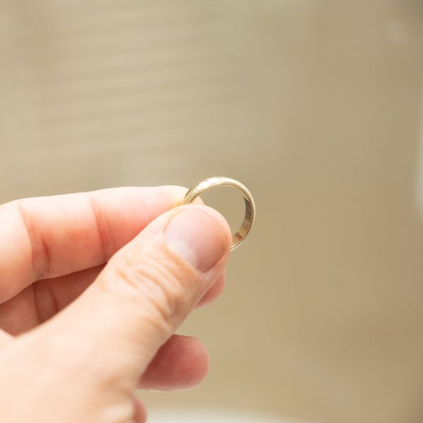 Hand Holding Thin Gold Wedding Ring