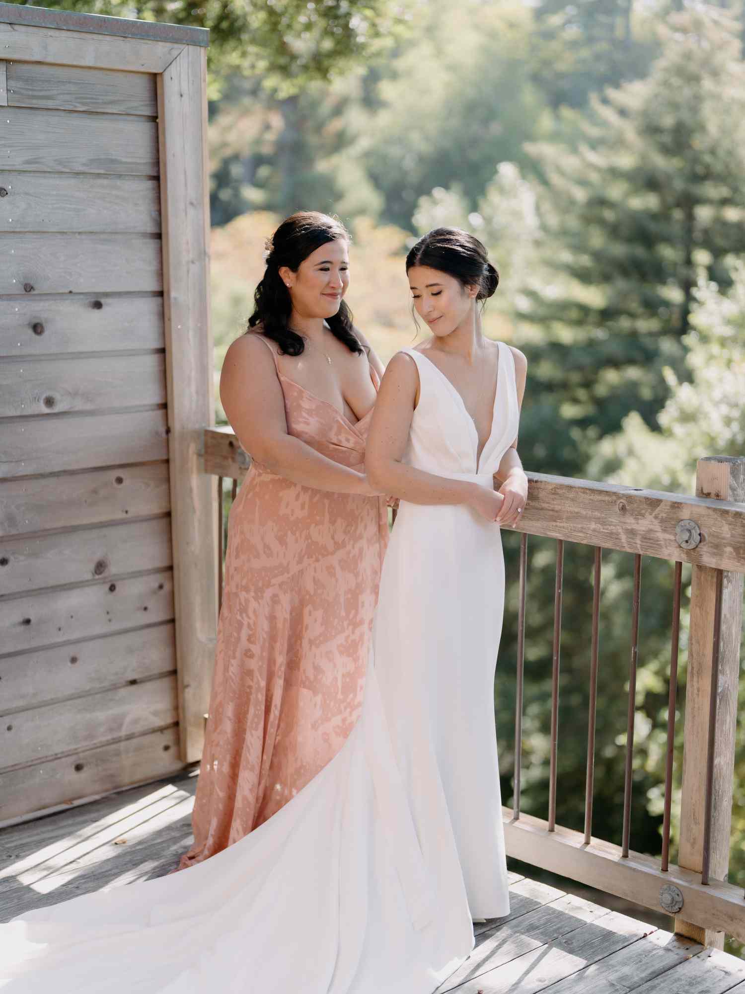 maid of honor helping the bride with her dress