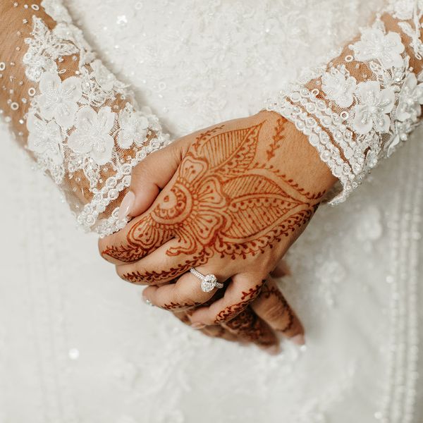 bride with henna on hands wearing a diamond ring