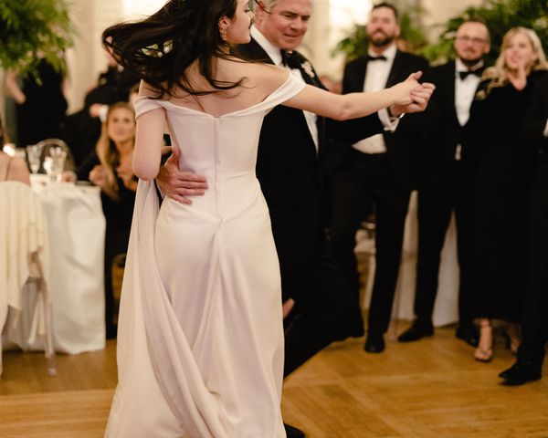 Bride in Off-the-Shoulder Wedding Dress Sharing Father-Daughter Dance With Dad in Black Tuxedo