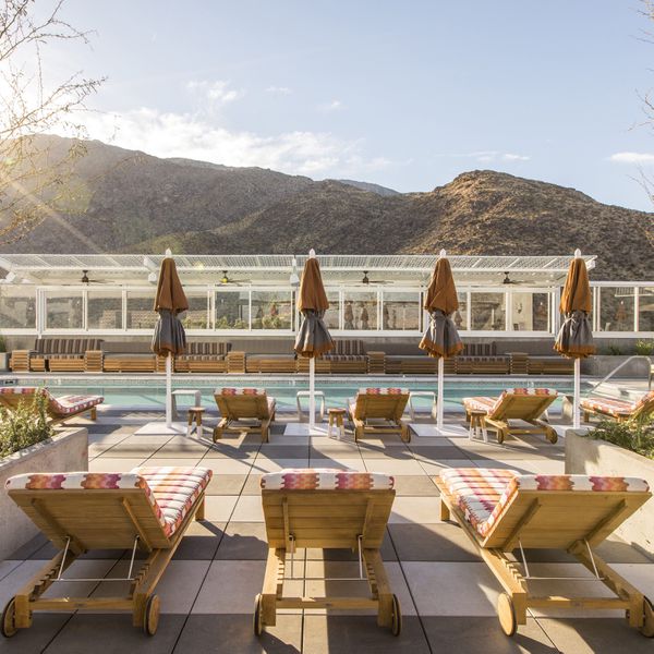 View of colorful pool chairs and umbrellas at the Kimpton Rowan Hotel Pool in Palm Springs, California, overlooking the mountains.