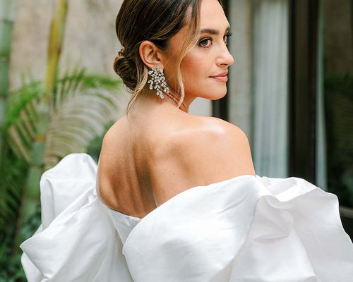 bridal portrait of influencer Rachel Love wearing an off-the-shoulder wedding dress and diamond leaf-motif earrings