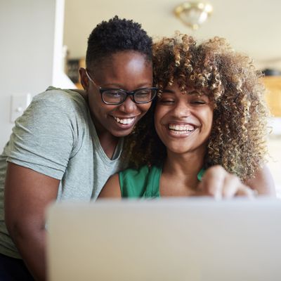 happy lesbian couple at laptop in the kitchen