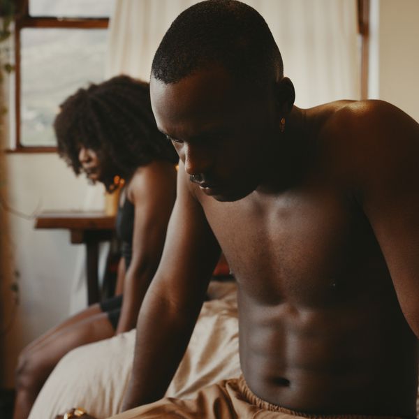 young couple sitting on bed having an argument